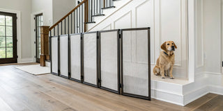 A portable dog safety guard installed on stairs with a dog sitting behind it.