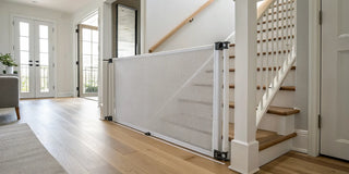 A retractable baby gate installed at the bottom of a staircase.