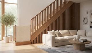 Neutral fabric baby gate installed across an unusual angled staircase with wooden banisters