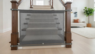 The Stair Barrier fabric safety gate installed on a wooden banister staircase in a modern home