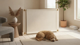 A premium fabric safety gate on a staircase landing with a calm dog resting beside it in a bright modern home