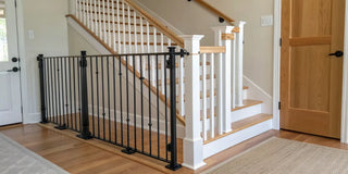 A stair gate secured to a banister using y spindles.