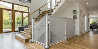 A retractable safety gate installed at the bottom of a home's staircase.