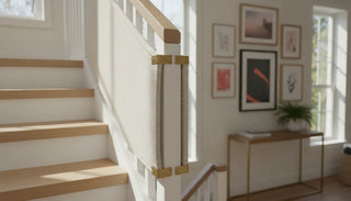 Fabric stair safety gate installed between white banisters
